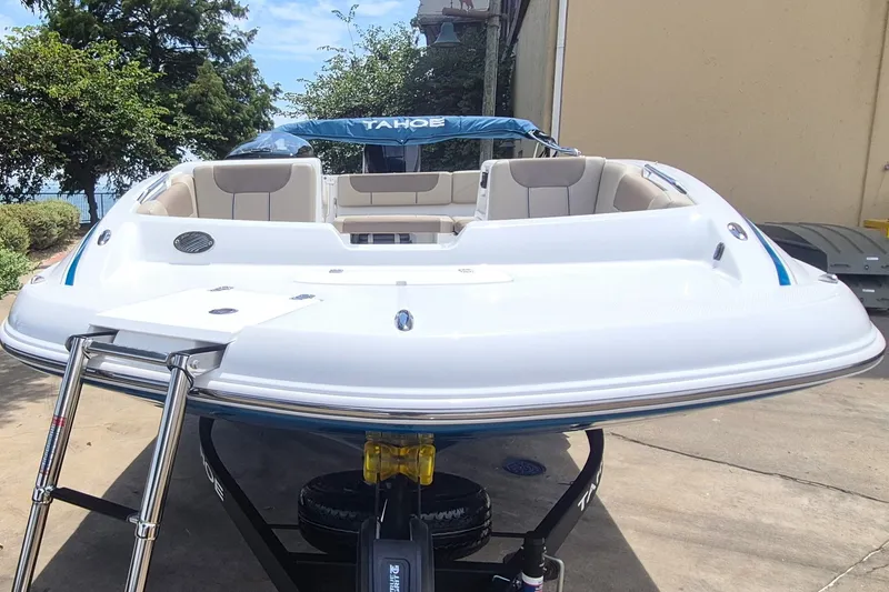 Slide: The Image of 2027 Tahoe 1950 boat with sleek design, docked outdoors. - 2
