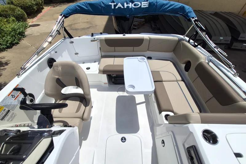 Slide: The Image of 2027 Tahoe 1950 boat interior with beige seating, steering wheel, and table. - 12