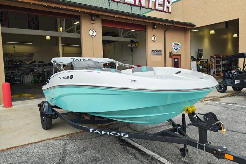 Slide: The Image of 2027 Tahoe T16 boat in mint green on trailer outside service center. - 1