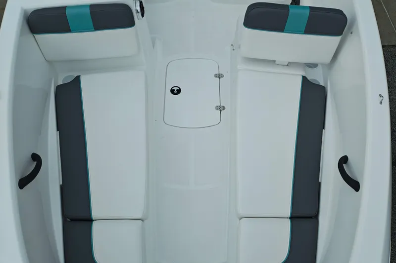Slide: The Image of 2027 Tahoe T16 boat interior with white and gray seating, teal accents, and storage hatch. - 7