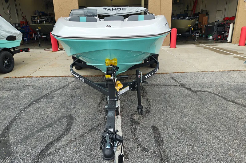 Slide: The Image of 2027 Tahoe T16 boat on trailer, parked outside a garage. - 2