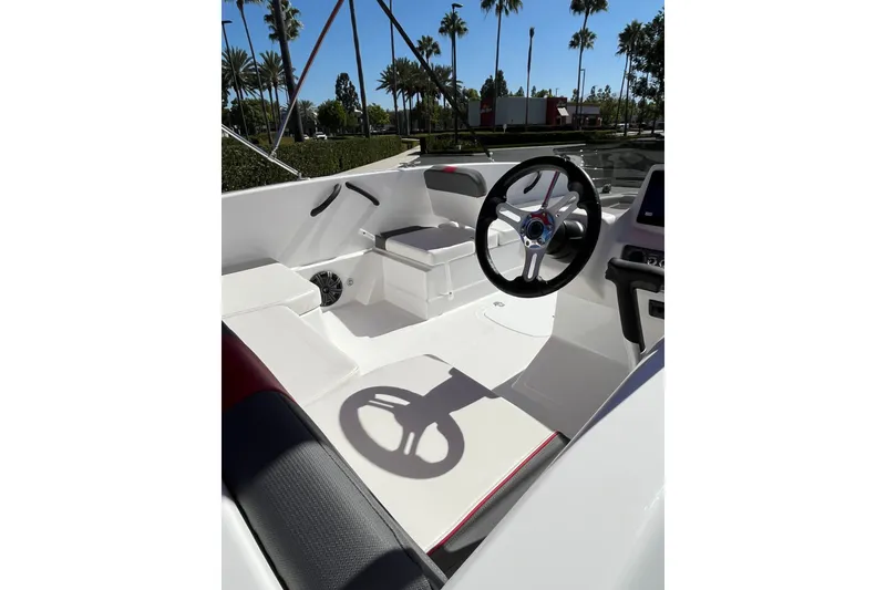 Slide: The Image of 2027 Tahoe T18 boat interior with steering wheel, white seating, and palm trees in the background. - 9