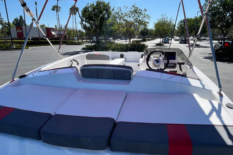 Slide: The Image of 2027 Tahoe T18 boat interior with seating and steering wheel in a sunny parking lot. - 8
