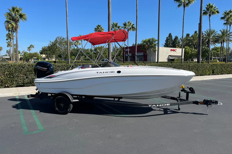 The Image of 2027 Tahoe T18 boat with red canopy on trailer in sunny parking lot. - 0