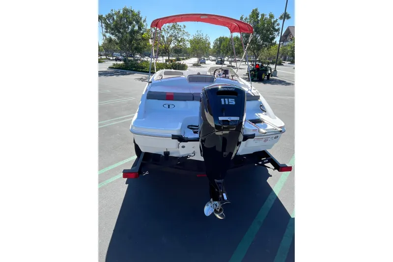 Slide: The Image of 2027 Tahoe T18 boat with Mercury 115 engine, parked outdoors under a red canopy. - 5