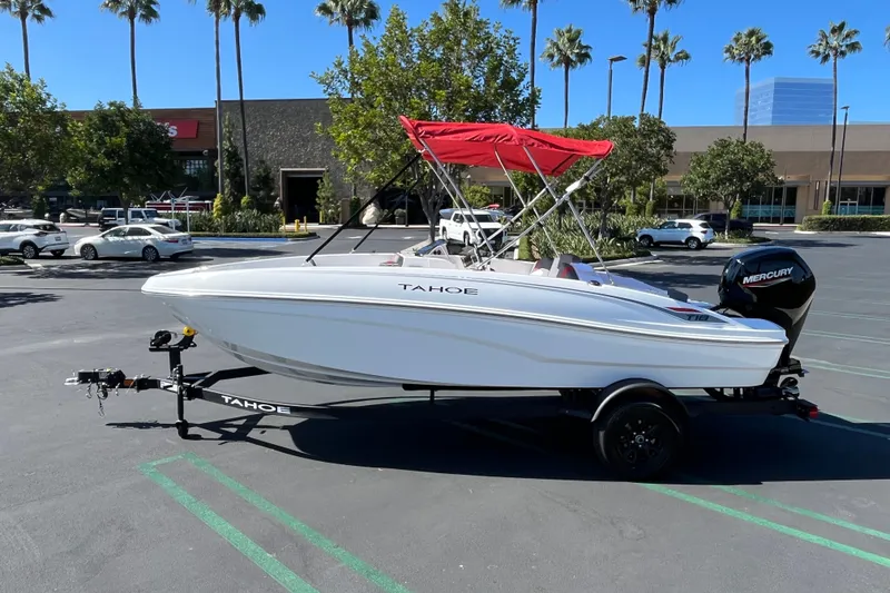 Slide: The Image of 2027 Tahoe T18 boat with red canopy on trailer in parking lot. - 4