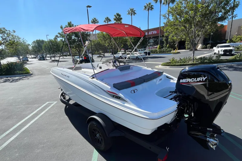 Slide: The Image of 2027 Tahoe T18 boat with red canopy and Mercury engine in a parking lot. - 6