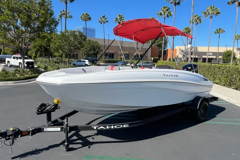 Slide: The Image of 2027 Tahoe T18 boat with red canopy on trailer in sunny parking lot. - 1