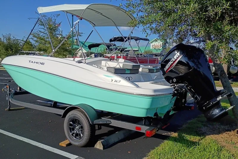 Slide: The Image of 2027 Tahoe T18 boat with Mercury engine on trailer, parked outdoors. - 2