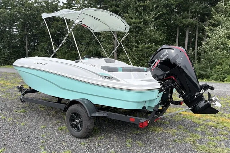 Slide: The Image of 2027 Tahoe T18 boat with canopy on trailer, parked outdoors near trees. - 5