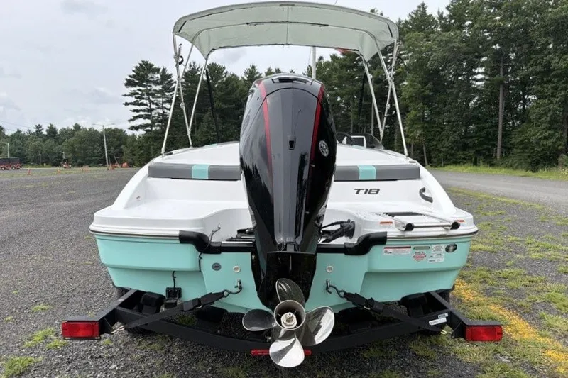 Slide: The Image of 2027 Tahoe T18 boat with outboard motor, parked on a gravel surface. - 7
