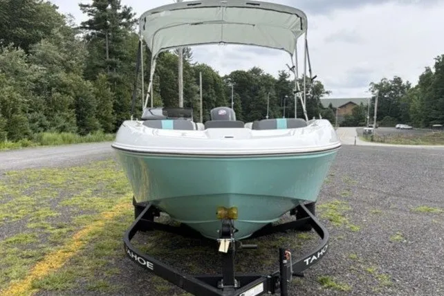 Slide: The Image of 2027 Tahoe T18 boat on trailer, parked outdoors with trees in the background. - 6
