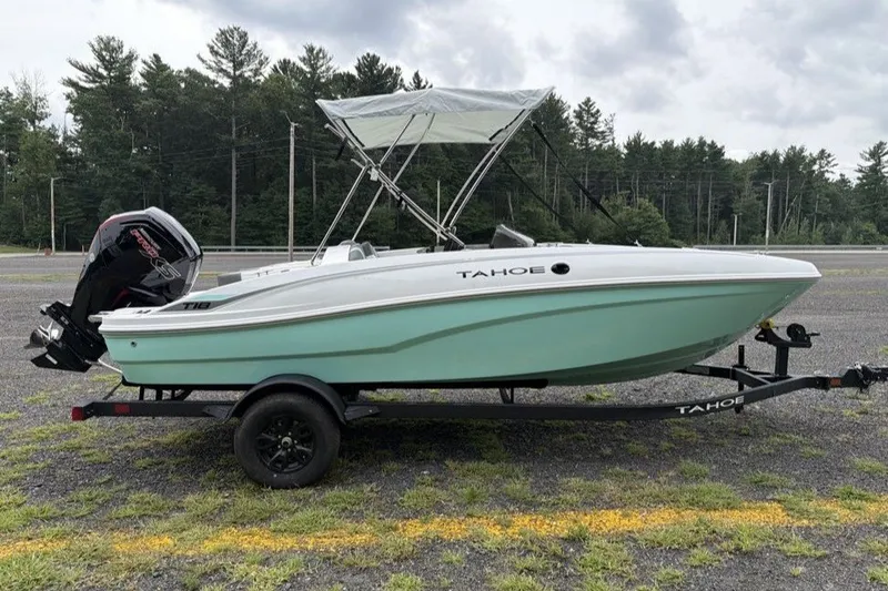 Slide: The Image of 2027 Tahoe T18 boat on trailer, parked outdoors with trees in background. - 3