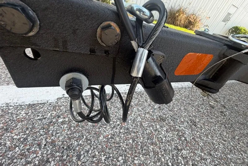 Slide: The Image of Trailer hitch assembly of a 2027 Tahoe T18, featuring cables and safety lock. - 70