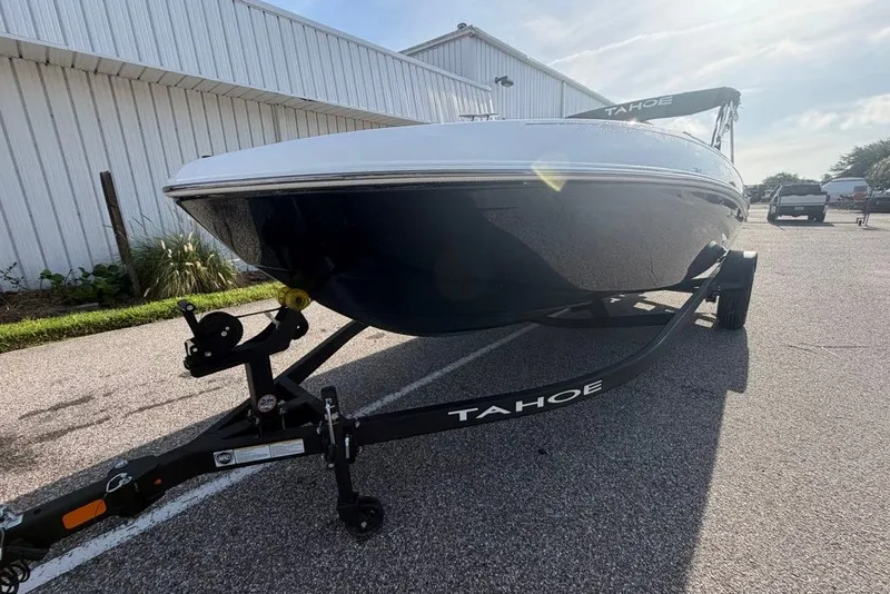 Slide: The Image of 2027 Tahoe T18 boat on trailer, parked outdoors near a white building. - 71