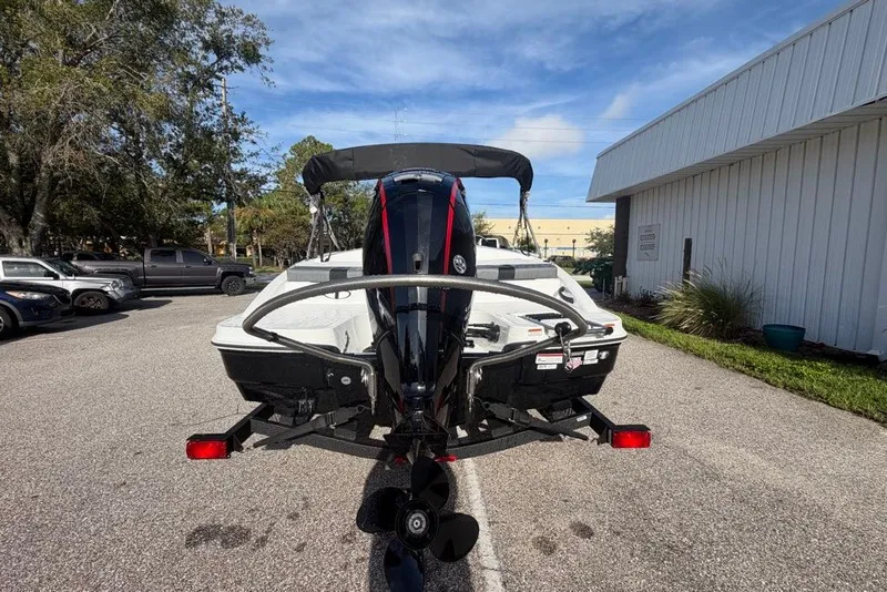 Slide: The Image of 2027 Tahoe T18 boat with outboard motor on a trailer in a parking lot. - 72