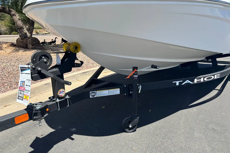 Slide: The Image of 2027 Tahoe T16 boat on trailer, parked on asphalt, with visible hitch and winch. - 5