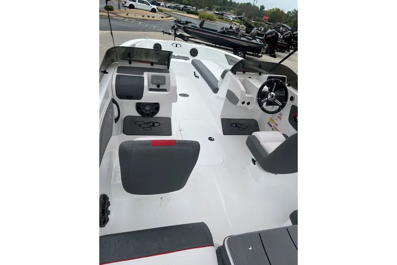 Slide: The Image of 2027 Tahoe T21 boat interior with steering wheel and seating, parked outdoors. - 2
