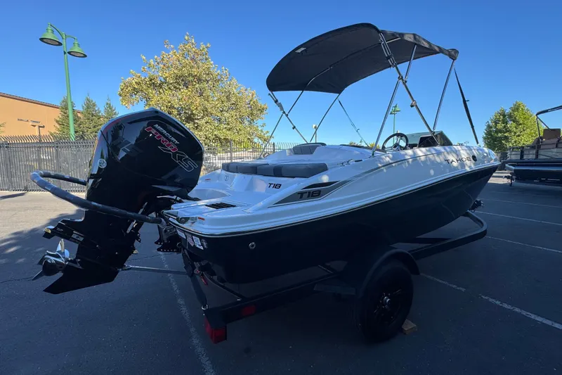 Slide: The Image of 2027 Tahoe T18 boat with outboard motor, parked outdoors under clear sky. - 5