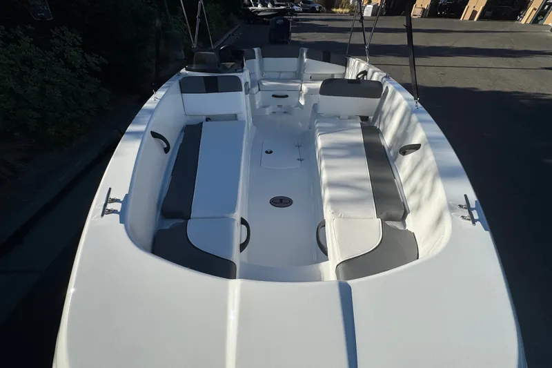 Slide: The Image of 2027 Tahoe T18 boat interior with white and gray seating, docked outdoors. - 9
