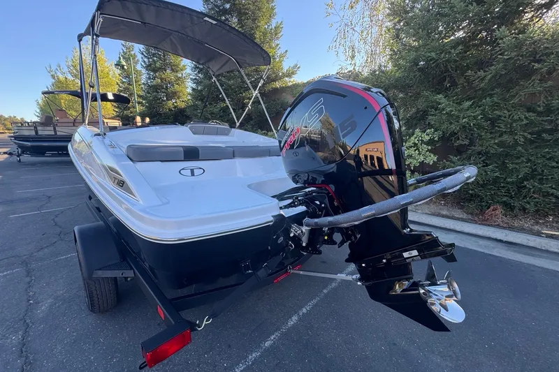 Slide: The Image of 2027 Tahoe T18 boat with outboard motor, parked outdoors on a trailer. - 11