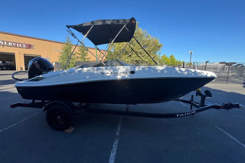 Slide: The Image of 2027 Tahoe T18 boat with canopy on trailer, parked outdoors near service building. - 4