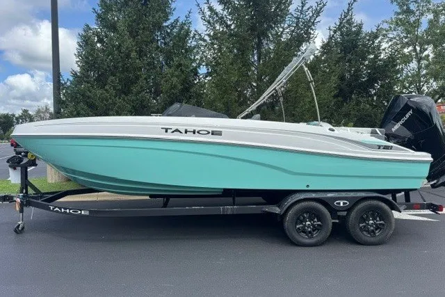 Slide: The Image of 2027 Tahoe T21 boat in teal on trailer, parked outdoors. - 1