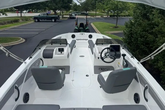 Slide: The Image of 2027 Tahoe T21 boat interior with modern seating and steering, parked in a lot. - 3