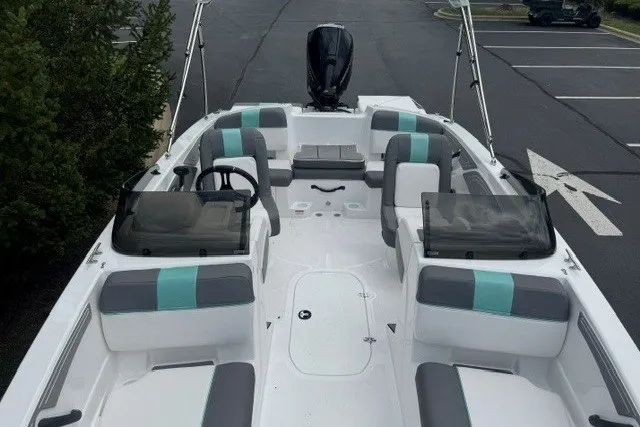 Slide: The Image of 2027 Tahoe T21 boat interior with teal and gray seating, parked in a lot. - 4