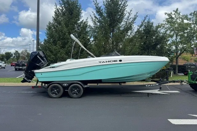 The Image of 2027 Tahoe T21 boat on trailer, parked outdoors, under a partly cloudy sky. - 0