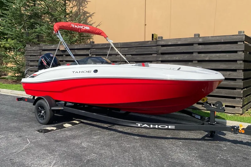 Slide: The Image of Red 2027 Tahoe T18 boat on trailer, parked outdoors with cover. - 1