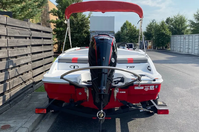 Slide: The Image of 2027 Tahoe T18 boat with red and white design, parked outdoors. - 2
