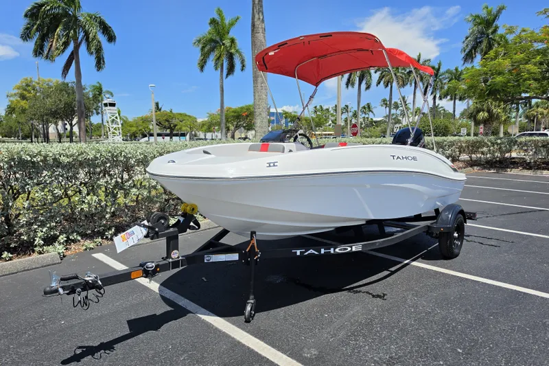 Slide: The Image of 2027 Tahoe T16 boat with red canopy on trailer in sunny parking lot. - 70