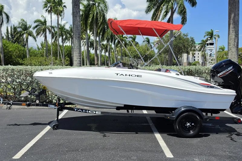The Image of 2027 Tahoe T16 boat with red canopy, parked under palm trees. - 0