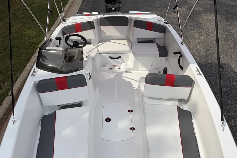 Slide: The Image of 2027 Tahoe T18 boat interior with red and gray seating, steering wheel, and windshield. - 13