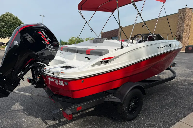 Slide: The Image of 2027 Tahoe T18 boat with red and white design, parked on a trailer. - 1