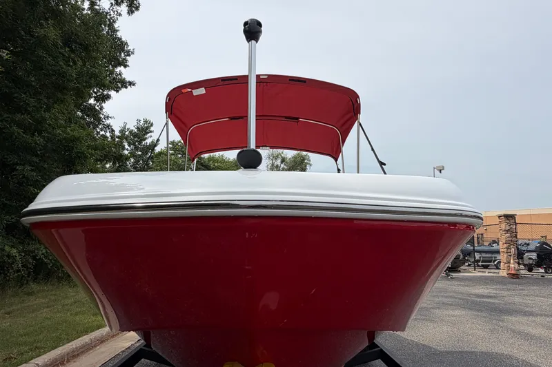 Slide: The Image of 2027 Tahoe T18 boat with red hull and canopy, parked outdoors. - 4