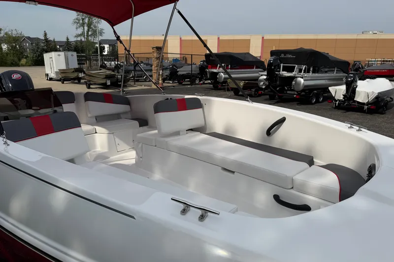Slide: The Image of 2027 Tahoe T18 boat interior with red and gray seating, parked outdoors. - 6