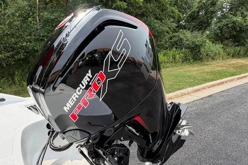 Slide: The Image of Mercury Pro XS outboard motor on a 2027 Tahoe T18 boat, parked near greenery. - 23
