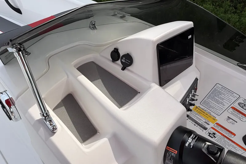 Slide: The Image of 2027 Tahoe T18 boat dashboard with controls and safety labels. - 15