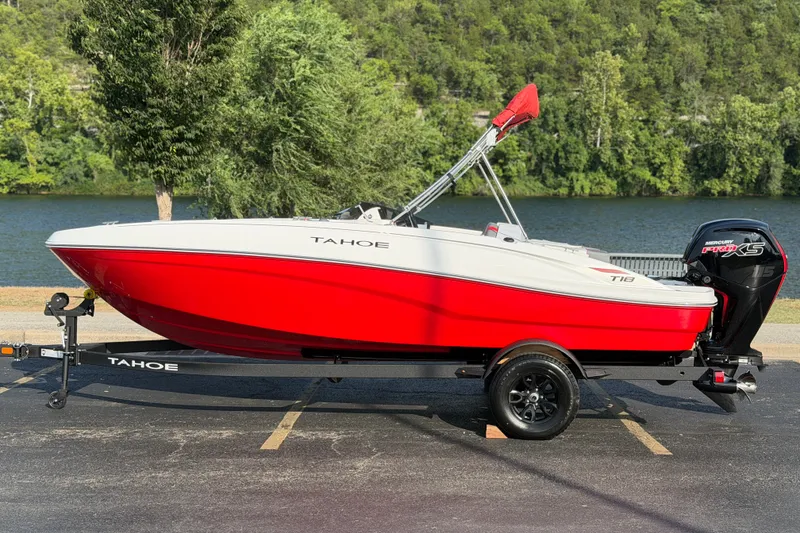 The Image of 2027 Tahoe T18 boat with red hull, parked near a scenic lake. - 0