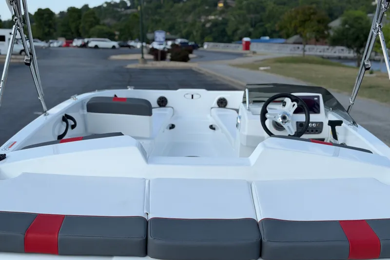 Slide: The Image of 2027 Tahoe T18 boat interior with modern steering and seating, parked outdoors. - 13