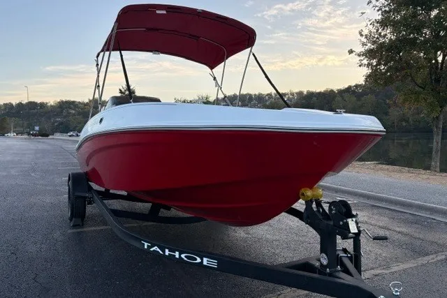 Slide: The Image of Red 2027 Tahoe T18 boat on trailer, parked near a scenic lake under a cloudy sky. - 6