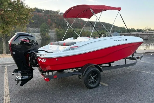 Slide: The Image of 2027 Tahoe T18 boat with red hull and Mercury engine, parked near scenic river. - 8