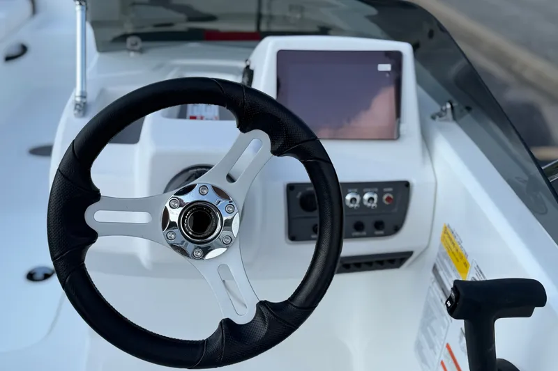 Slide: The Image of Steering wheel and dashboard of 2027 Tahoe T18 boat, featuring modern controls and display. - 15