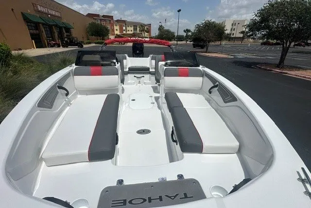 Slide: The Image of 2027 Tahoe T21 boat with spacious seating, parked outdoors under a clear sky. - 4