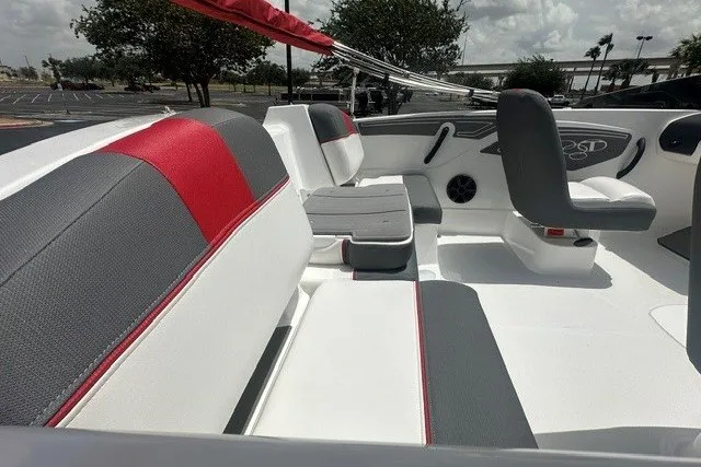 Slide: The Image of 2027 Tahoe T21 boat interior with red and gray seating, parked outdoors. - 11