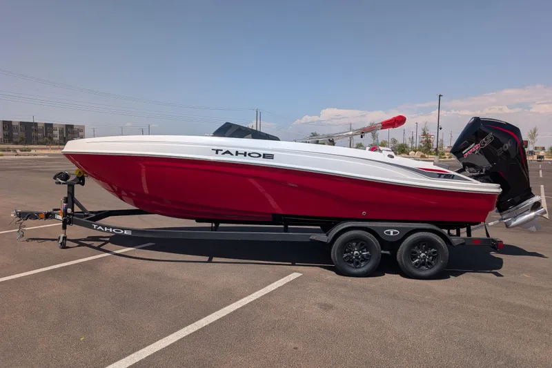 The Image of 2027 Tahoe T21 boat in red and white on a trailer in a parking lot. - 0