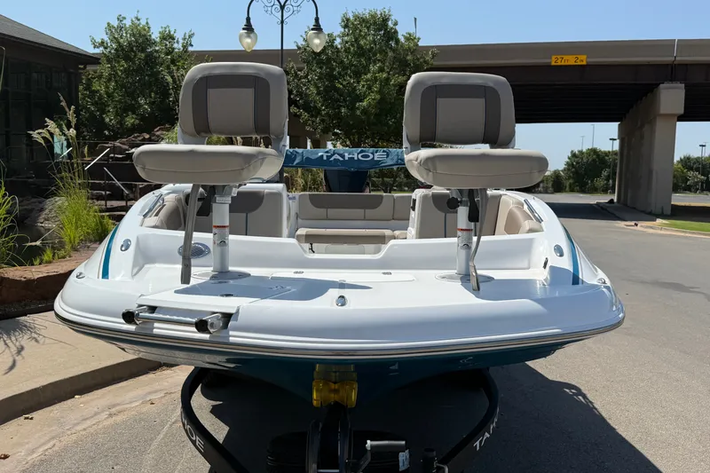 Slide: The Image of 2027 Tahoe 1950 boat with dual seats, parked outdoors under a bridge. - 3
