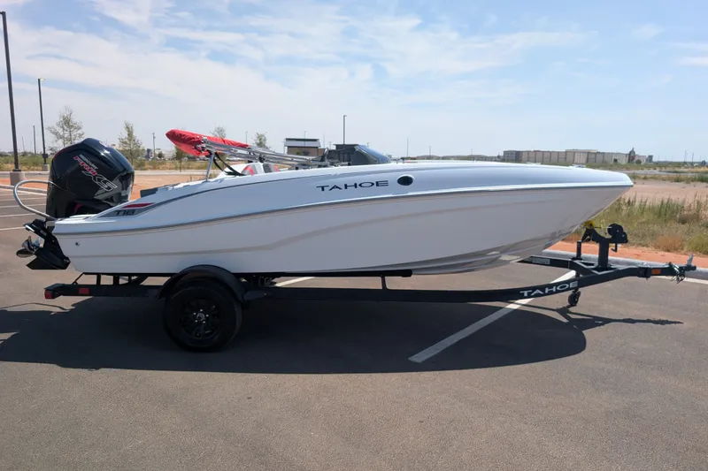 Slide: The Image of 2027 Tahoe T18 boat on trailer, parked outdoors under clear sky. - 4